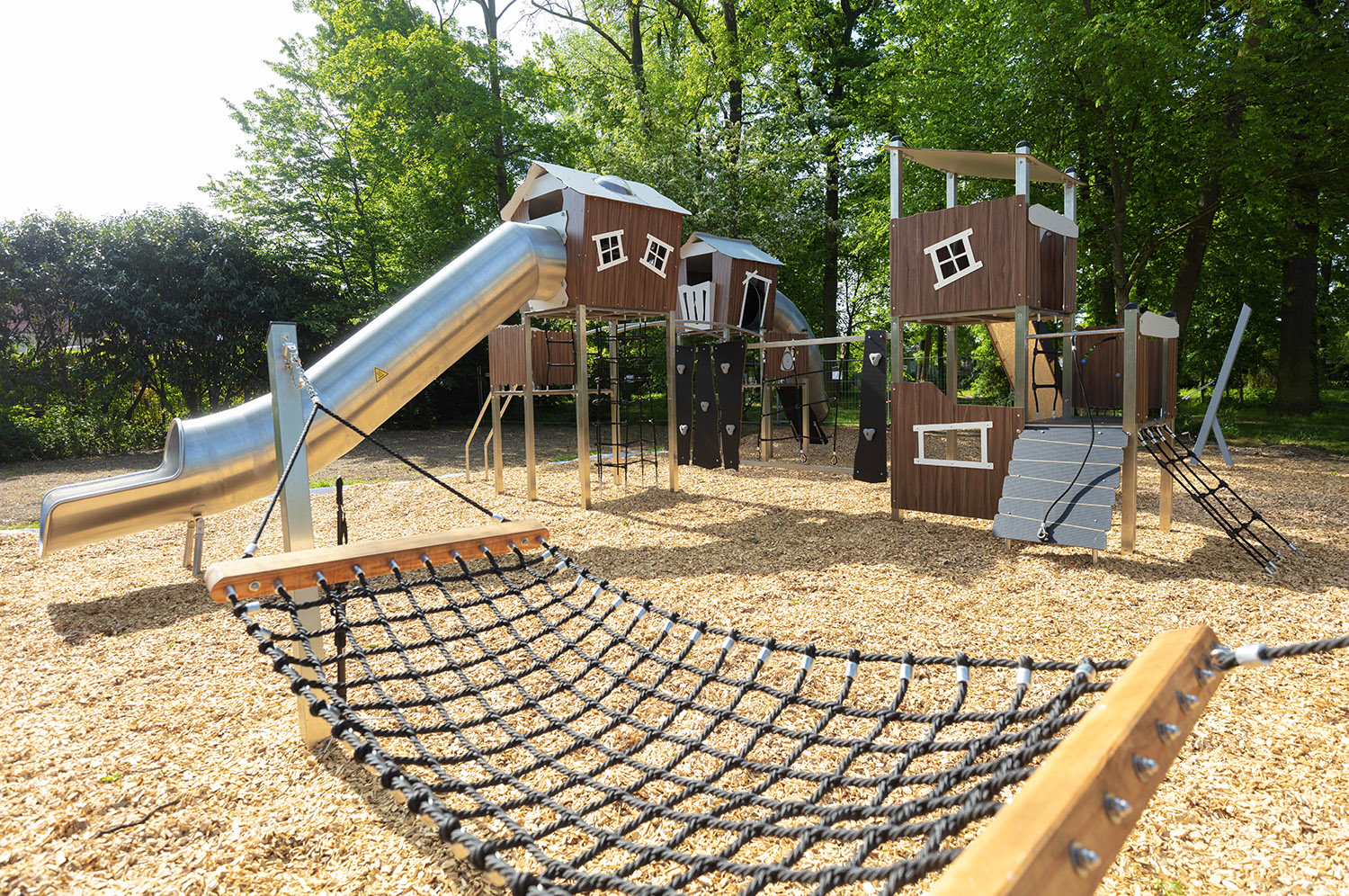 Structures de jeux pour enfants dans un espace vert arboré